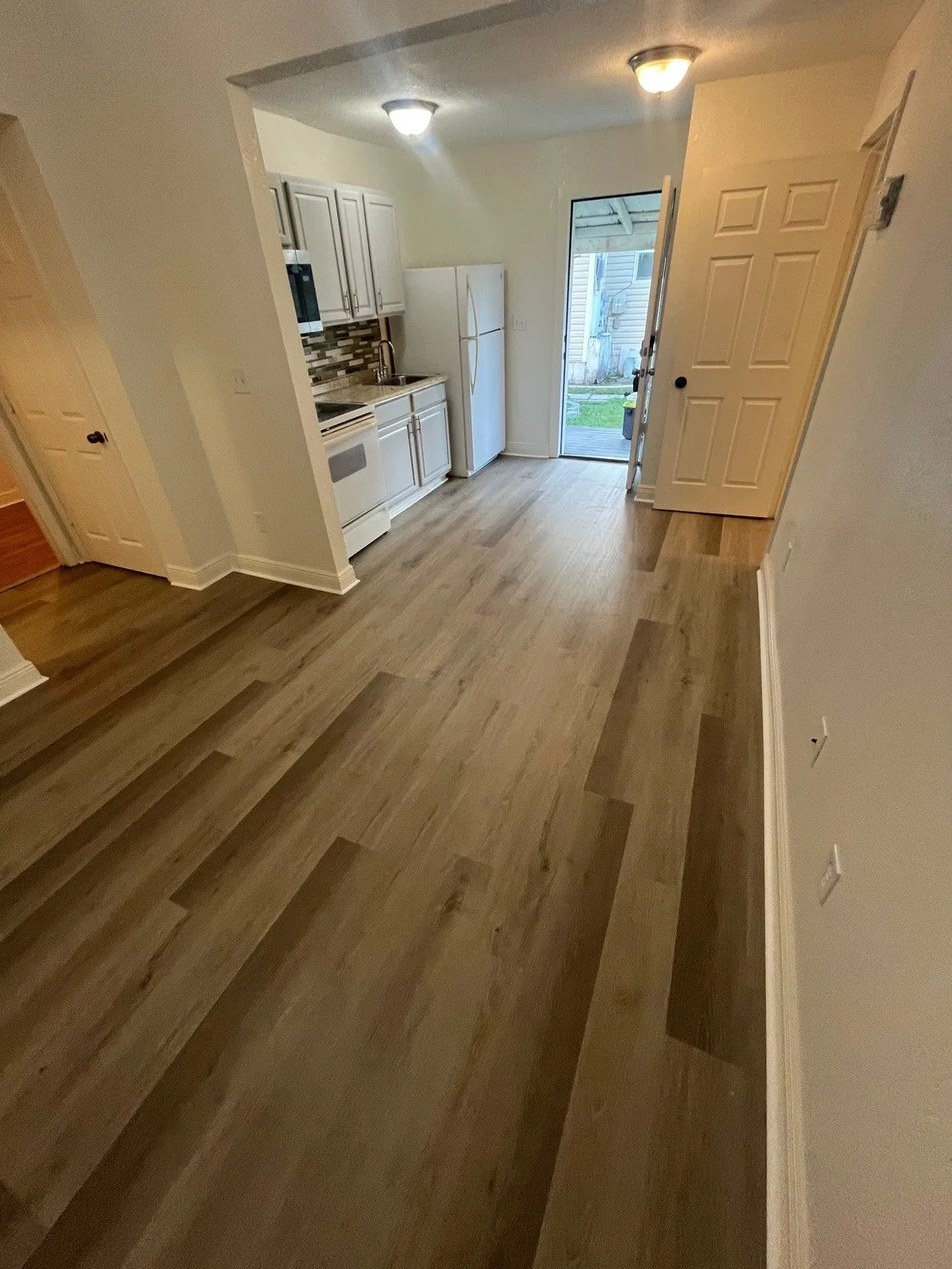 Living room and kitchen after laminate flooring installation in Tampa Heights, Tampa, FL