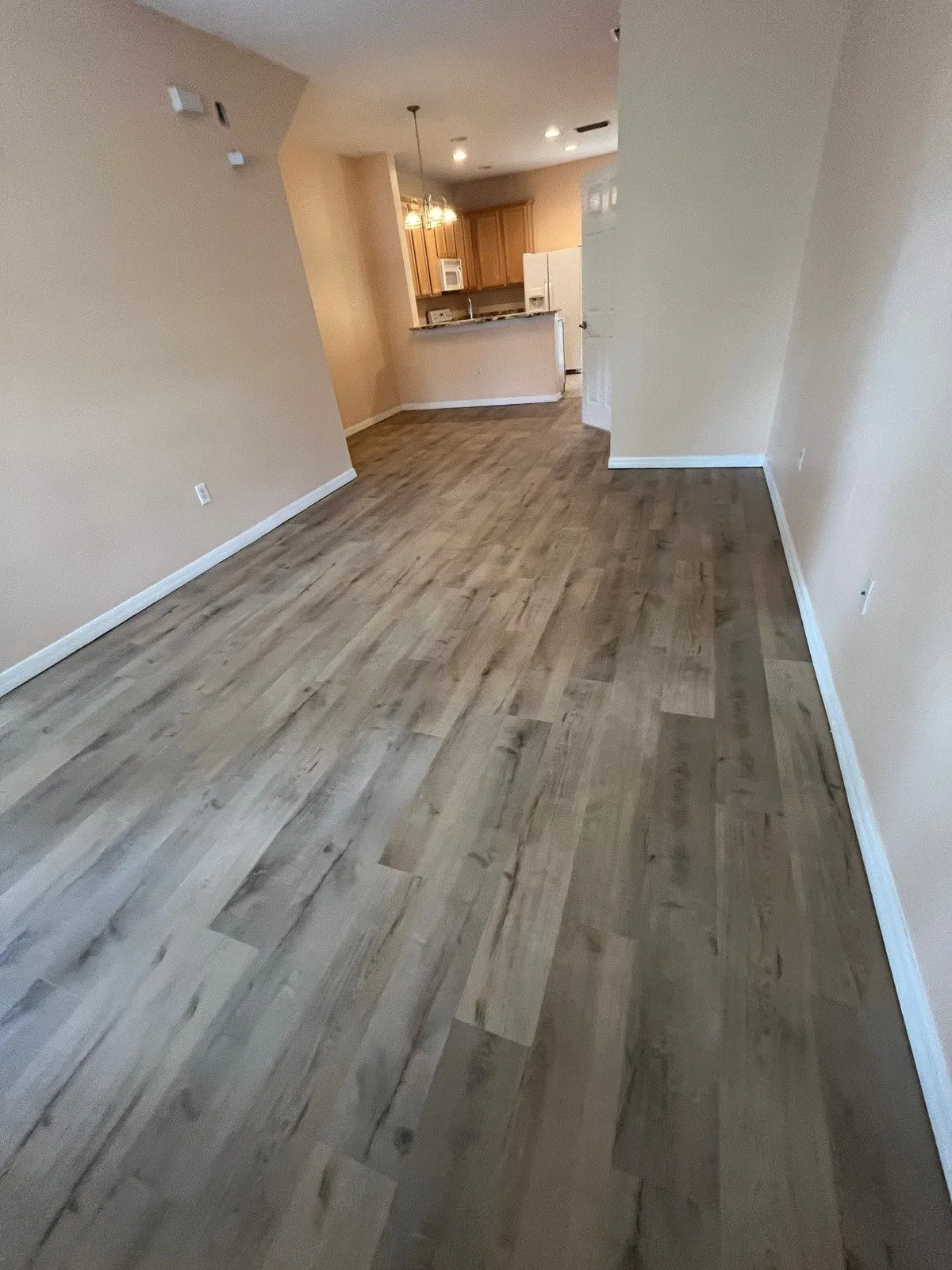 Living room and kitchen after LVP flooring installation in Carrollwood, Tampa, FL